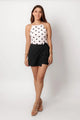 Falda short de vestir negra, vista frontal en modelo