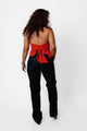 Blusa cuello halter roja, espalda descubierta con lazo, vista trasera en modelo