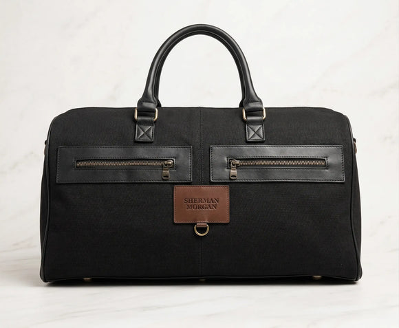 Bolso duffle Sherman Morgan de lona negra para hombre con detalles de vinipiel, maleta de viaje casual con bolsillos frontales de cierre y asas reforzadas.