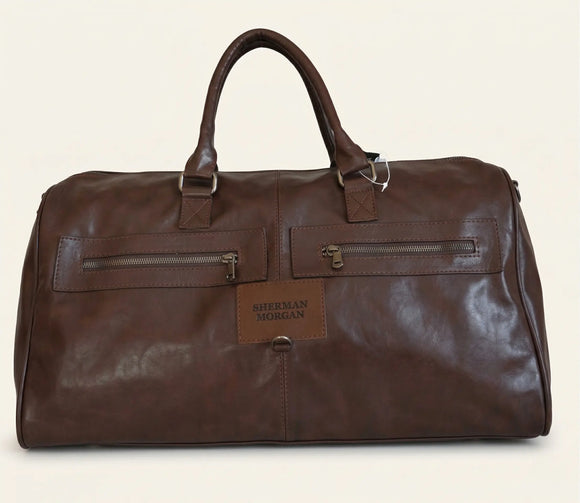 Bolso duffle Sherman Morgan en vinipiel color café chocolate, maleta de viaje estilo ejecutivo con textura tipo cuero, bolsillos frontales con cierre y placa de marca.