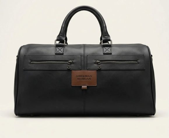 Bolso duffle Sherman Morgan en vinipiel color negro, maleta de viaje estilo ejecutivo con textura tipo cuero, bolsillos frontales con cierre y placa de marca.