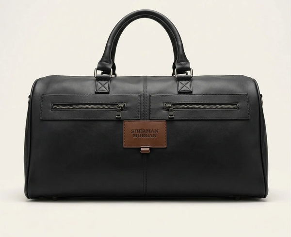 Bolso duffle Sherman Morgan en vinipiel color negro, maleta de viaje estilo ejecutivo con textura tipo cuero, bolsillos frontales con cierre y placa de marca.