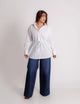 Camisa oversize blanca con listón, vista frontal en modelo, listón amarrado en cintura