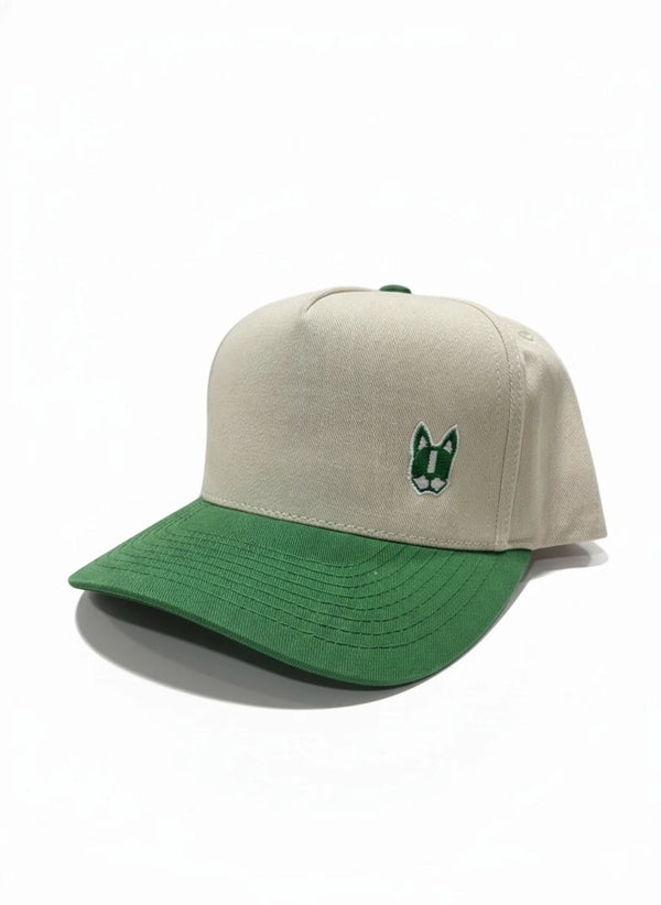 Vista lateral de gorra para hombre color beige con visera verde contrastante, detalle de parche ZAK bordado y perfil estructurado.