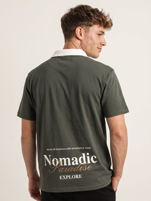 Polo oversize verde, bordado Nomadic Paradise en espalda baja